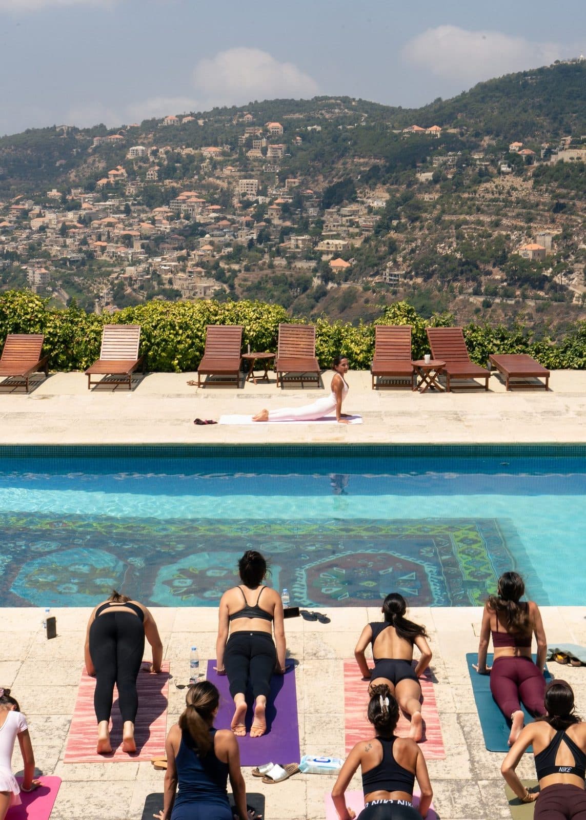 Guests on mats facing a pool at a previous Noonflows gathering