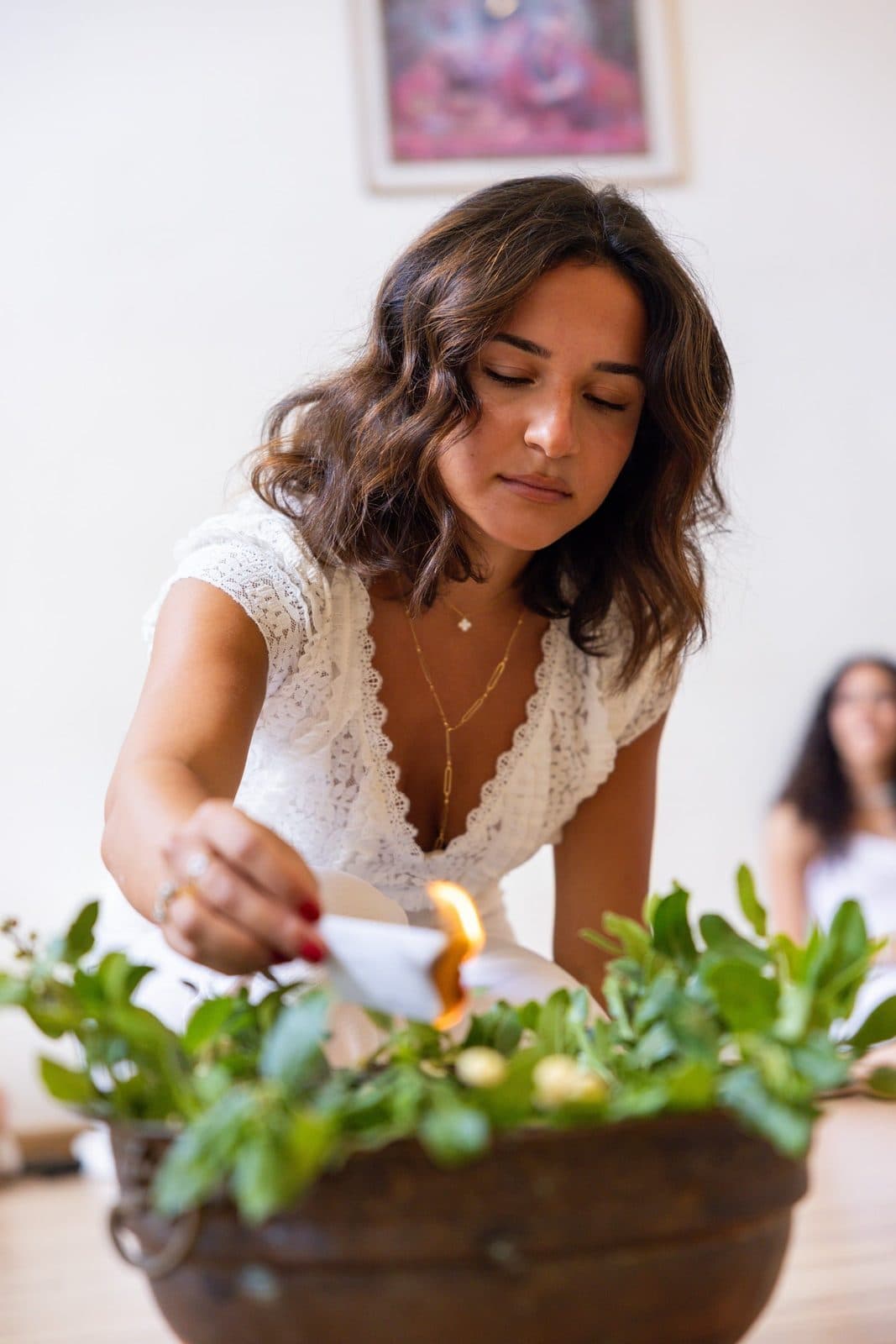Ninette AbouJamra lighting a candle in a bowl of greenery